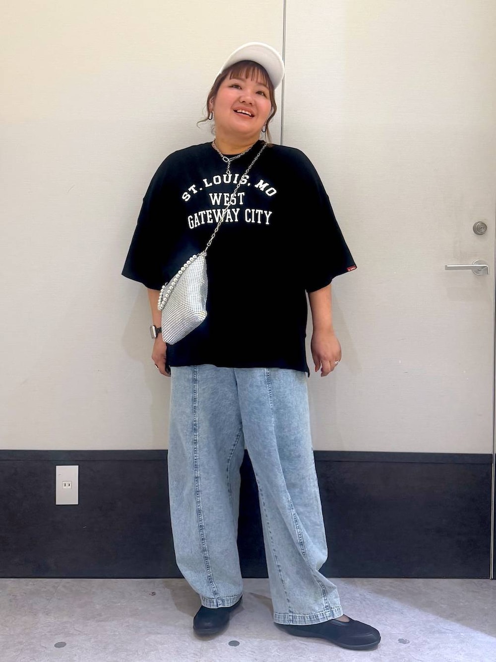 ブラック系のパンプス、シルバー系のショルダーバッグ、ブルー系のデニムパンツを着用したレディースの春コーディネートの3枚目の写真