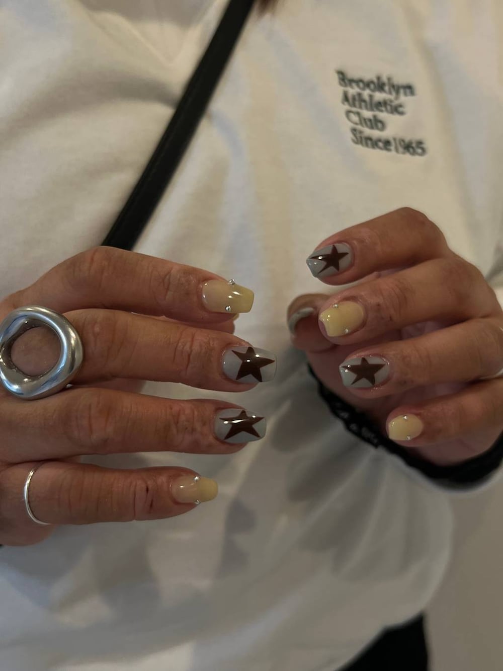 ブラック系のシャツ/ブラウス、ホワイト系のTシャツ/カットソーを着用したレディースの春コーディネートの2枚目の写真