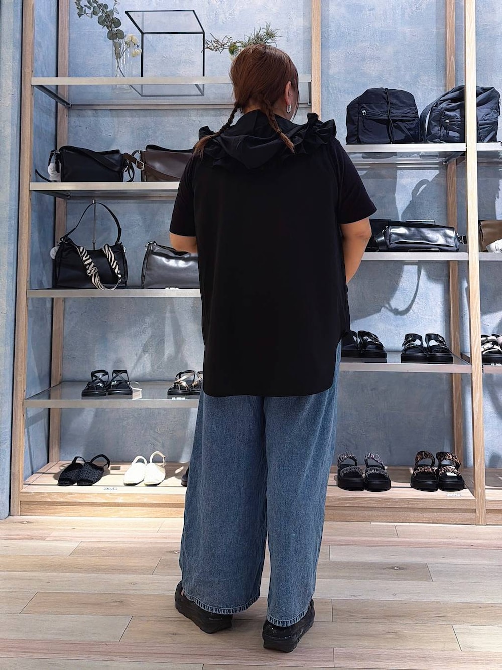 ブルー系のデニムパンツ、シルバー系のネックレスを着用したレディースの春コーディネートの3枚目の写真