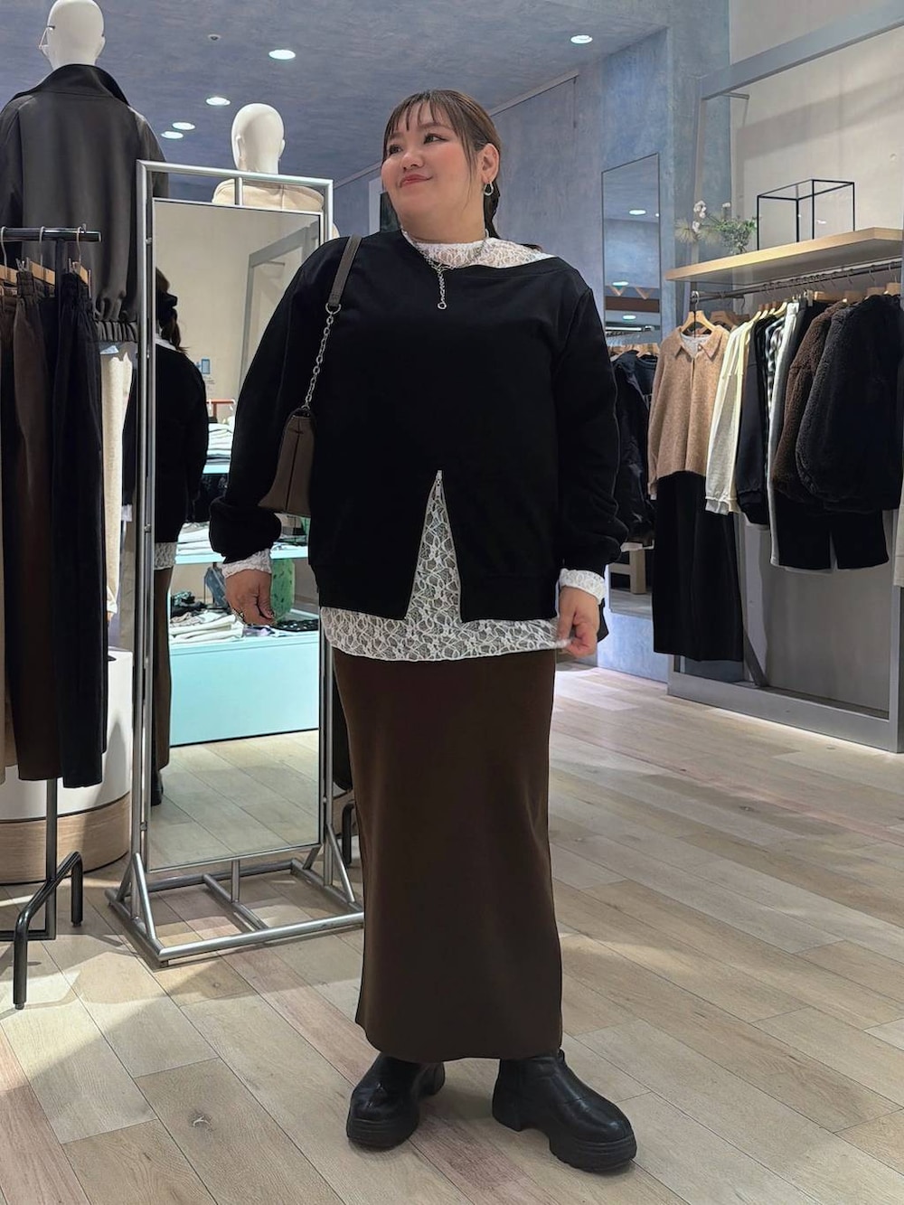 ブラウン系のスカート、ブラウン系のショルダーバッグ、ブラック系のTシャツ/カットソーを着用したレディースの冬コーディネートの2枚目の写真