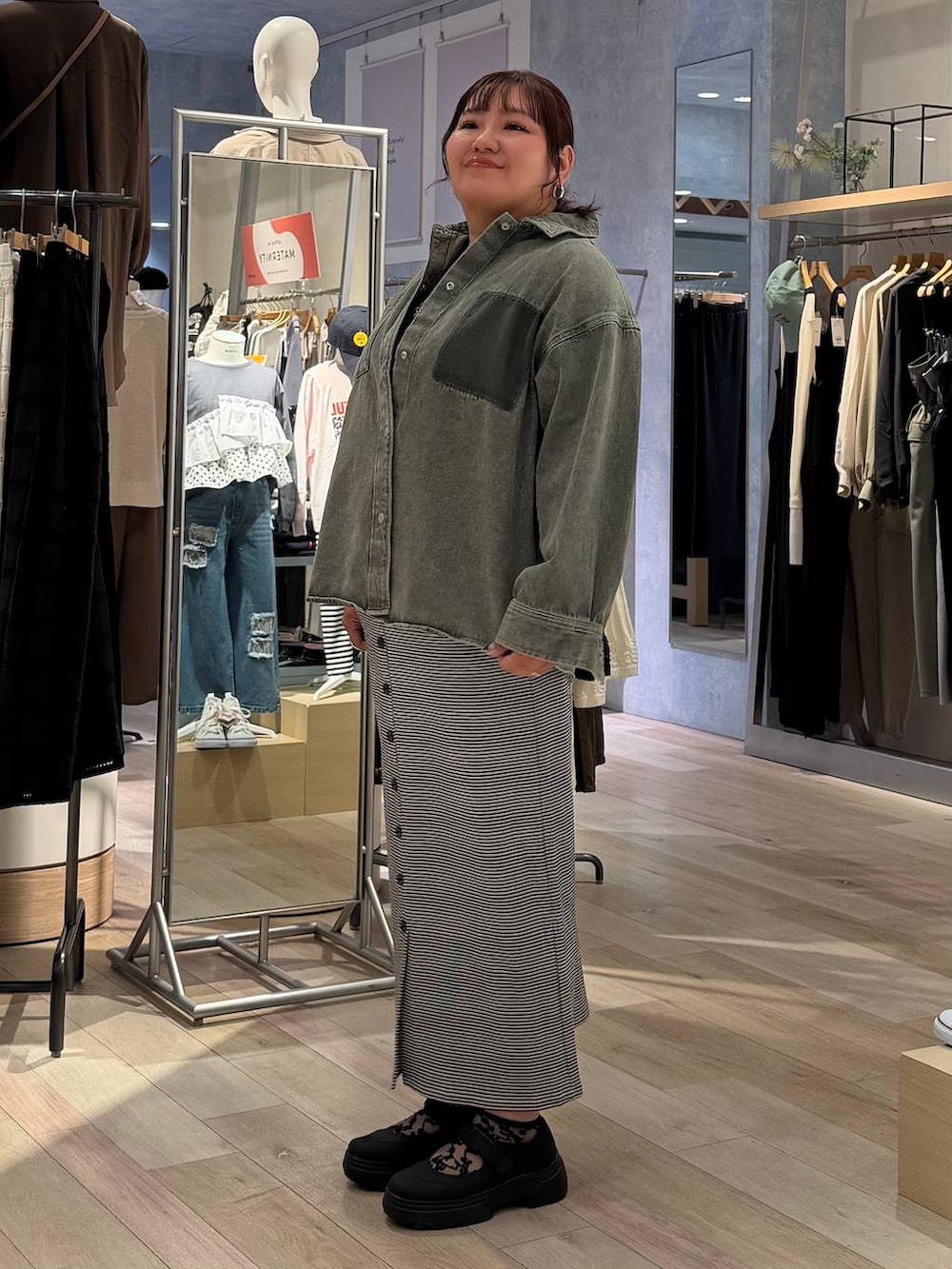 ブラック系のその他シューズ、ホワイト系のスカート、グリーン系のシャツ/ブラウスを着用したレディースの春コーディネートの2枚目の写真