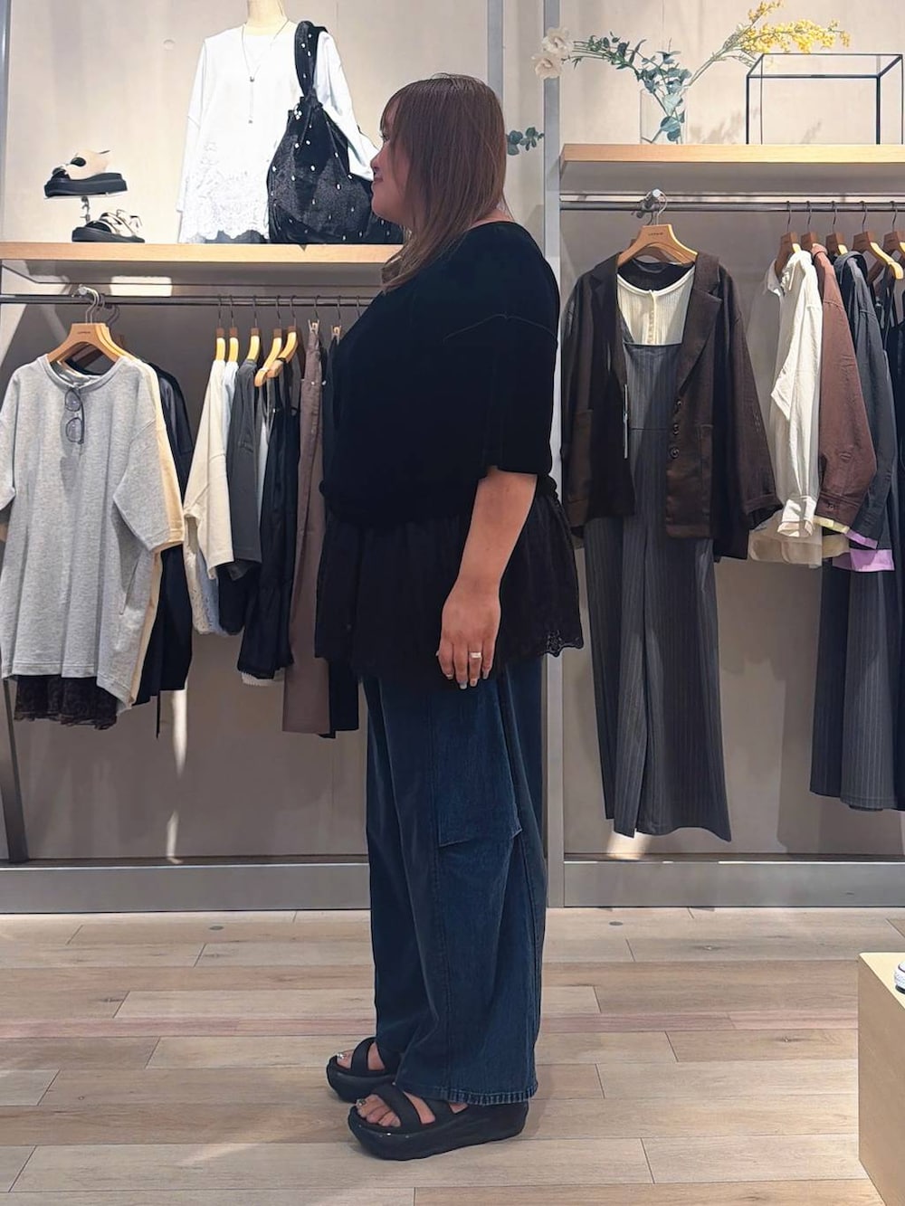 ブルー系のデニムパンツ、ブラック系のTシャツ/カットソー、ブラック系のキャミソールを着用したレディースの夏コーディネートの2枚目の写真