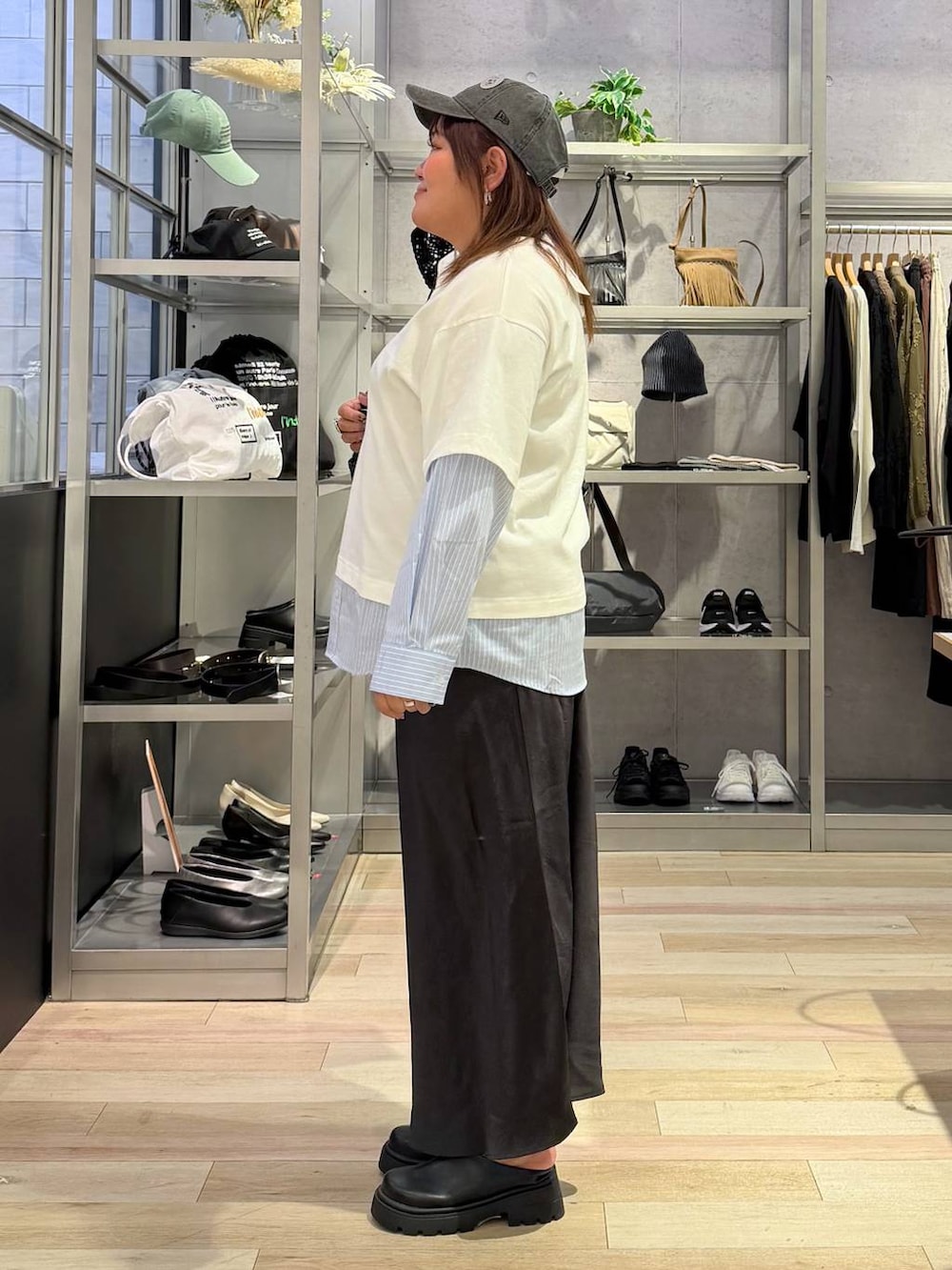 グレー系のショルダーバッグ、ブラック系のその他シューズ、ホワイト系のTシャツ/カットソーを着用したレディースの春コーディネートの2枚目の写真