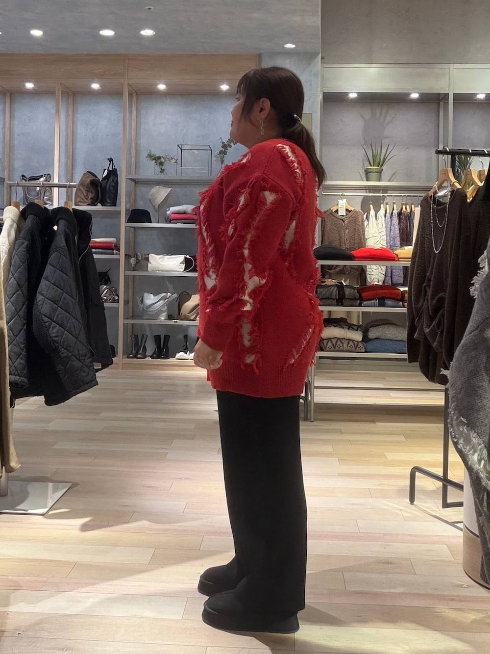 ブラック系のその他パンツ、レッド系のニット/セーター、ブラック系のその他シューズを着用したレディースの冬コーディネートの2枚目の写真