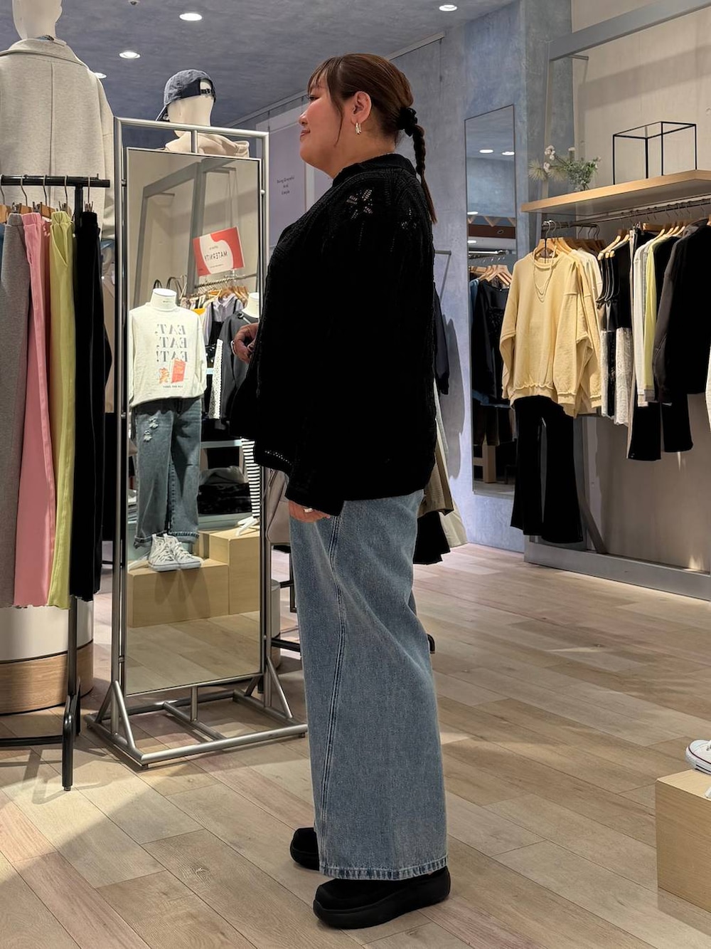 グレー系のボストンバッグ、ブラック系のTシャツ/カットソー、ブルー系のデニムパンツを着用したレディースの冬コーディネートの3枚目の写真