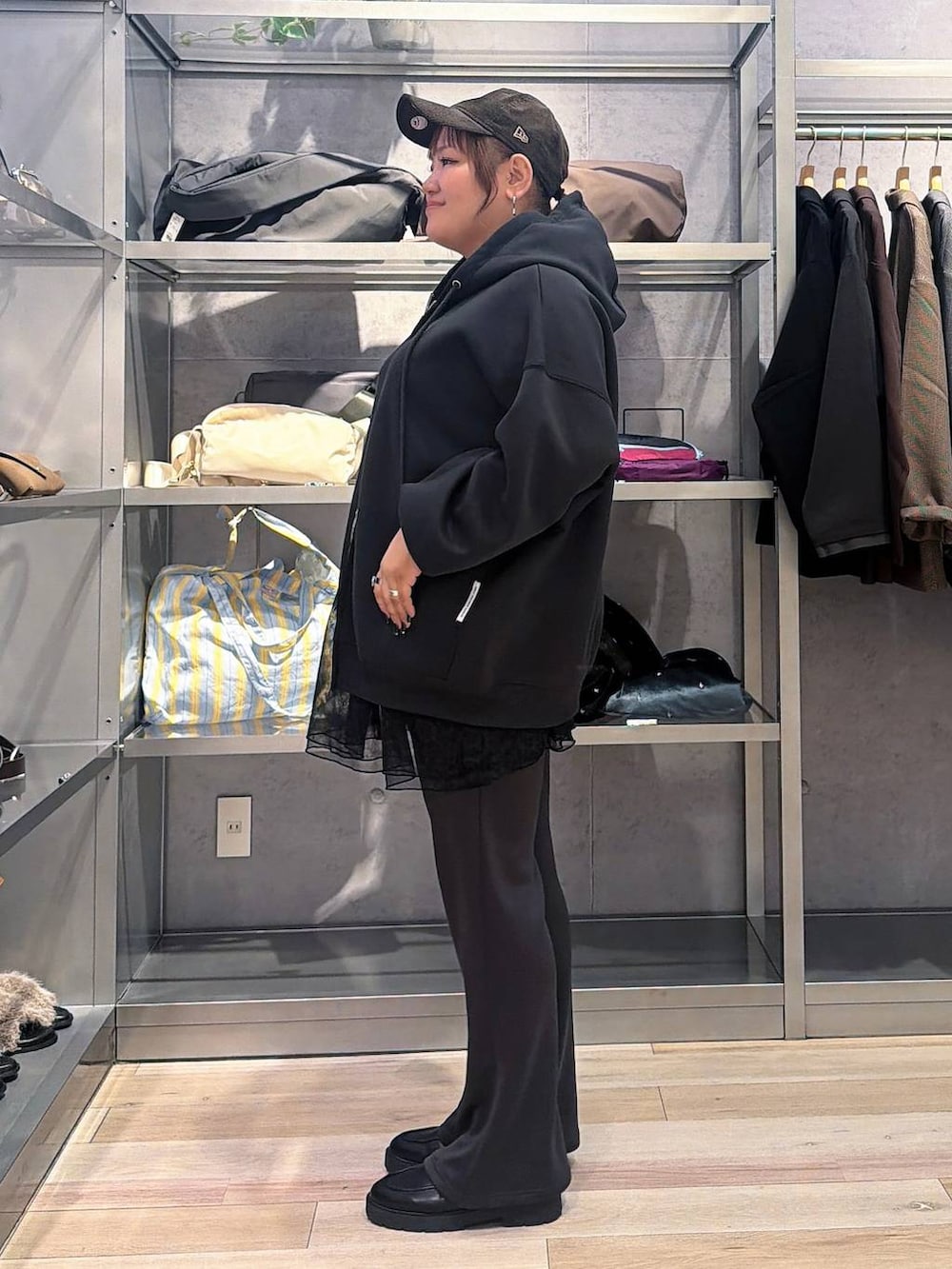 グレー系のパーカー、グレー系のその他パンツ、ブラウン系のキャップを着用したレディースの秋コーディネートの2枚目の写真