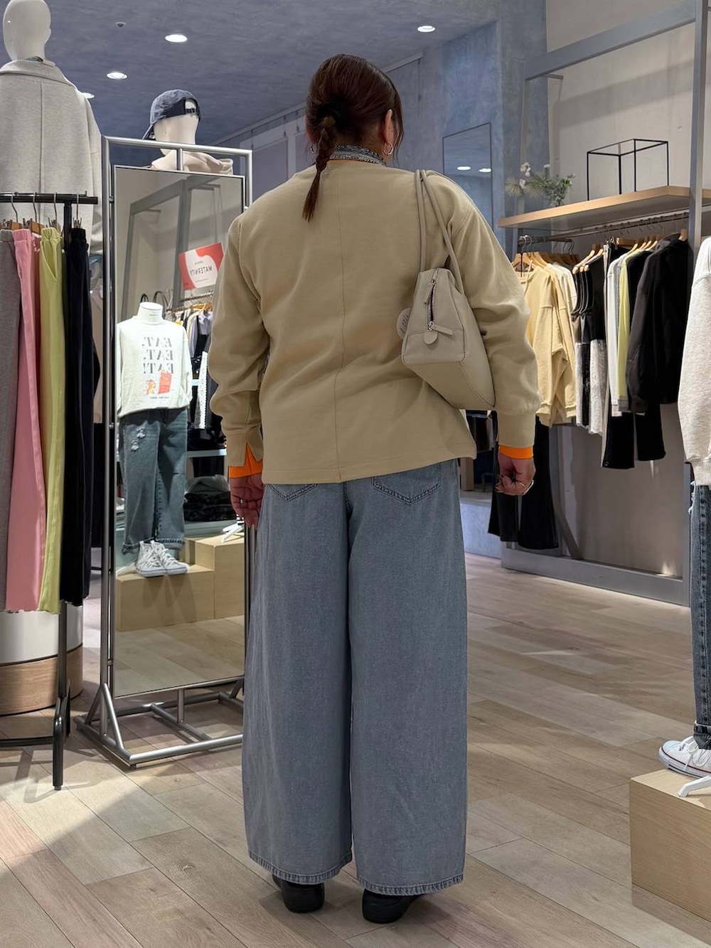 ブルー系のデニムパンツ、ホワイト系のボストンバッグ、ブラック系のその他シューズを着用したレディースの冬コーディネートの3枚目の写真