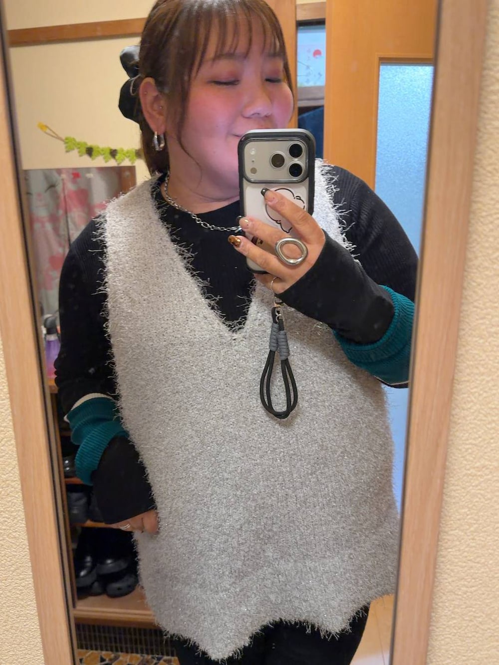 ブラック系のニット/セーター、グレー系のベスト、ブラック系のシュシュを着用したレディースの冬コーディネートの4枚目の写真