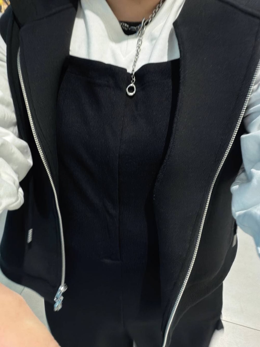 ブラック系のベスト、ホワイト系のTシャツ/カットソー、ブラック系のマタニティウェア/グッズを着用したレディースの冬コーディネートの5枚目の写真