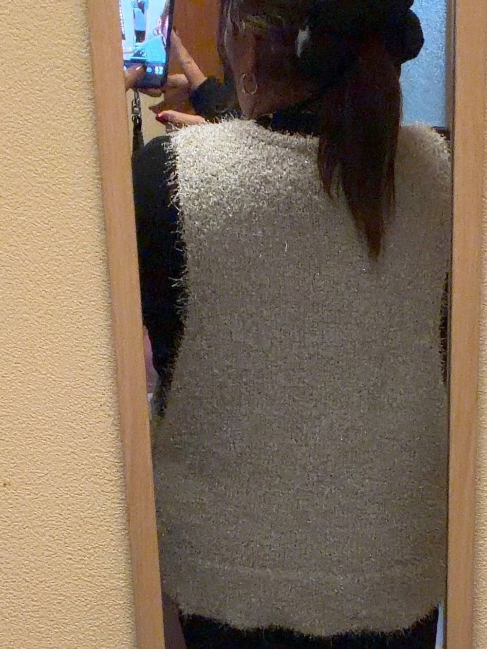 ブラック系のニット/セーター、グレー系のベスト、ブラック系のシュシュを着用したレディースの冬コーディネートの3枚目の写真