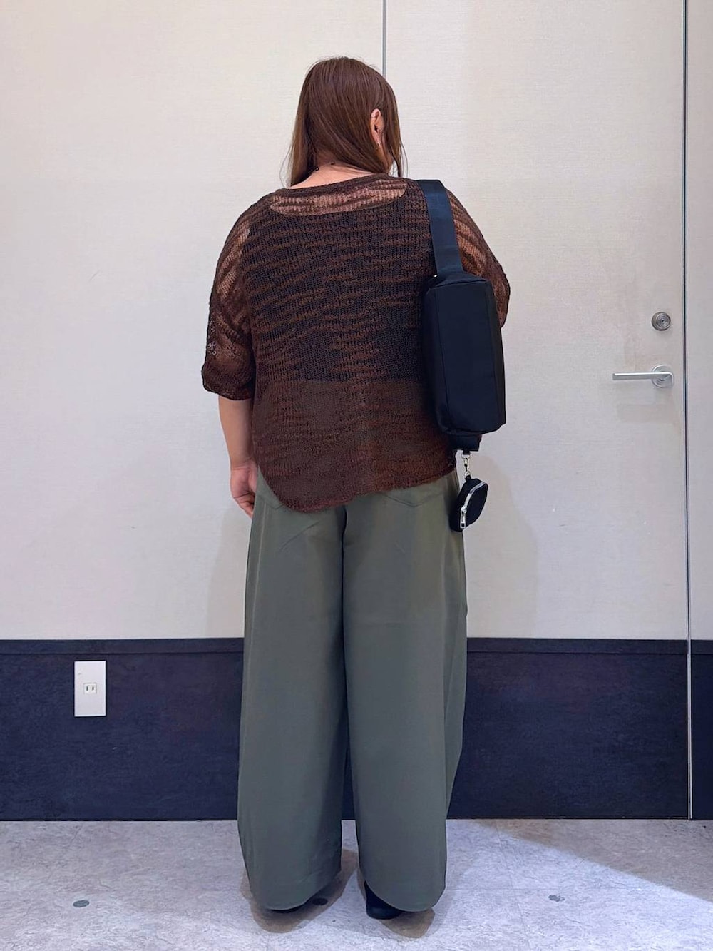 ブラック系のパンプス、ブラック系のショルダーバッグ、ブラウン系のニット/セーターを着用したレディースの夏コーディネートの3枚目の写真