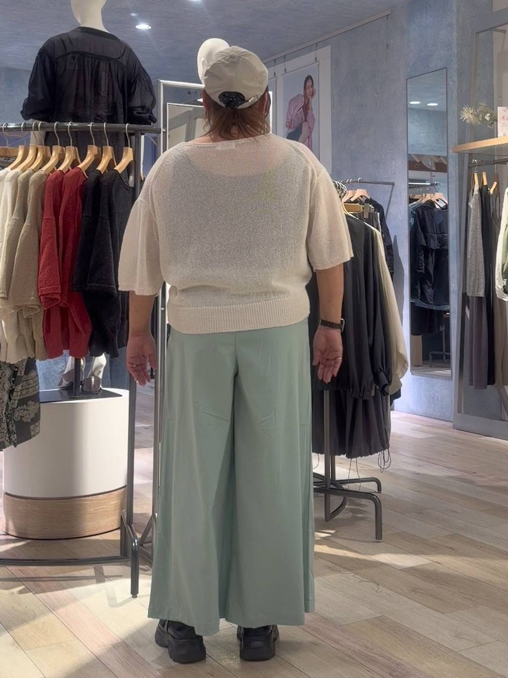 ブラック系のスニーカー、ホワイト系のニット/セーター、グリーン系のその他パンツを着用したレディースの春コーディネートの3枚目の写真