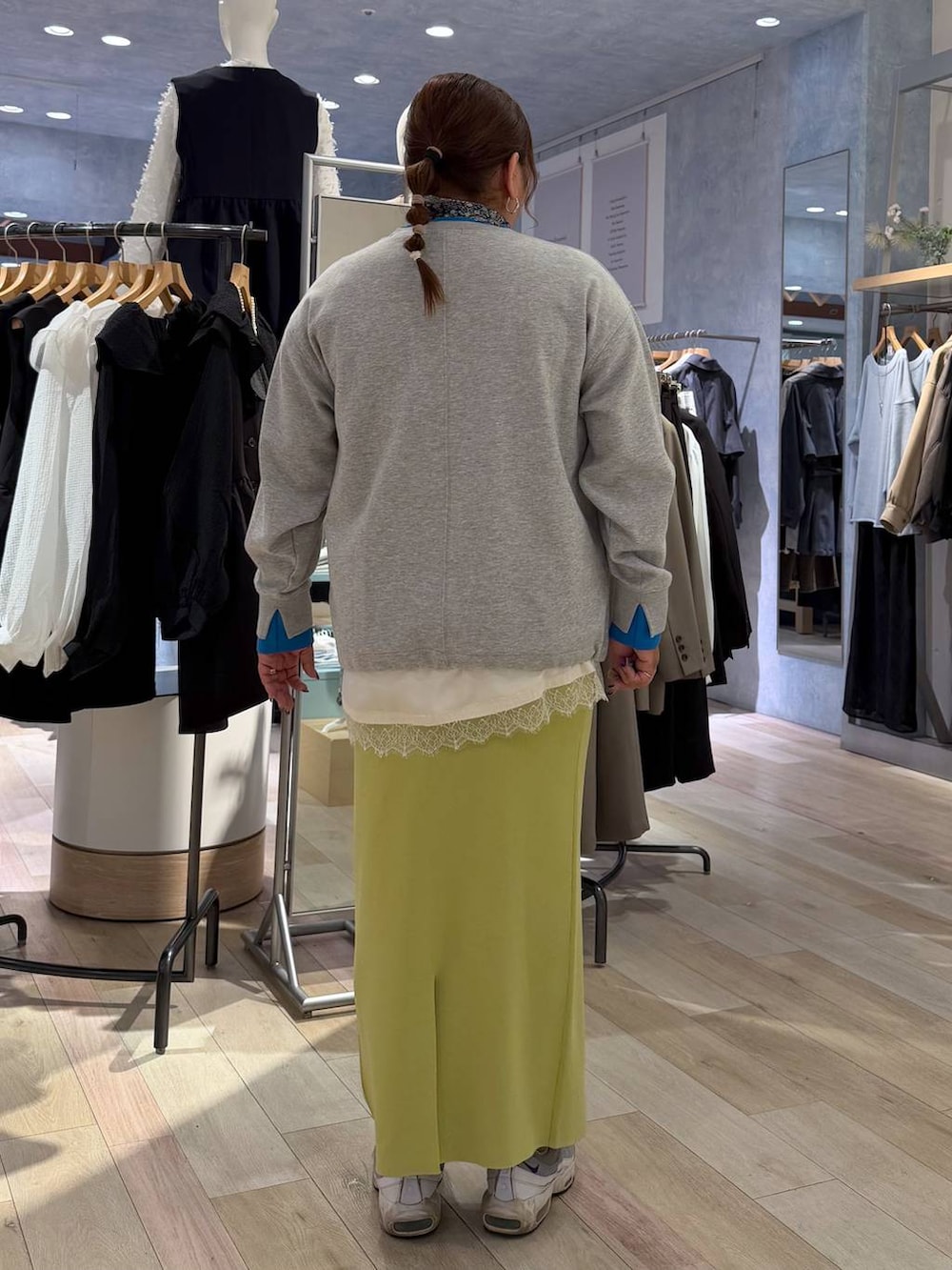 グリーン系のスカート、ホワイト系のキャミソール、ベージュ系のTシャツ/カットソーを着用したレディースの冬コーディネートの4枚目の写真