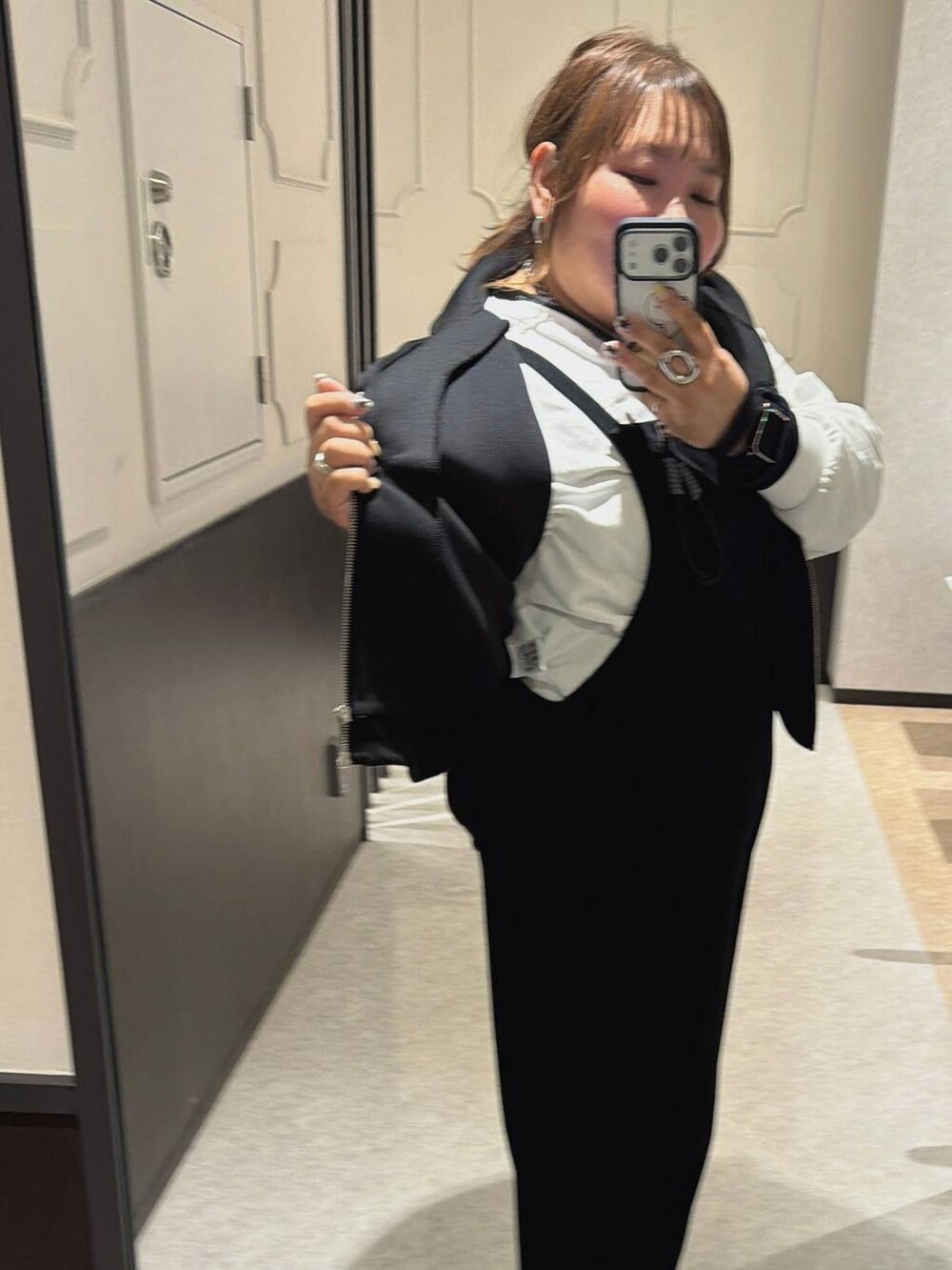 ブラック系のベスト、ホワイト系のTシャツ/カットソー、ブラック系のマタニティウェア/グッズを着用したレディースの冬コーディネートの2枚目の写真