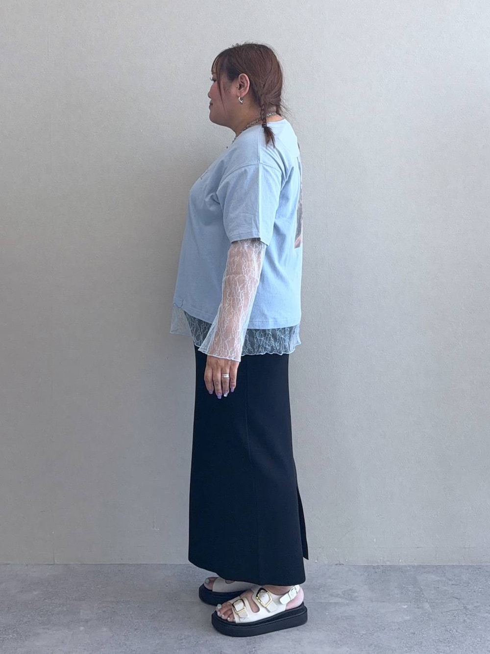 ブラック系のスカート、ホワイト系のサンダル、ブルー系のTシャツ/カットソーを着用したレディースの春コーディネートの2枚目の写真