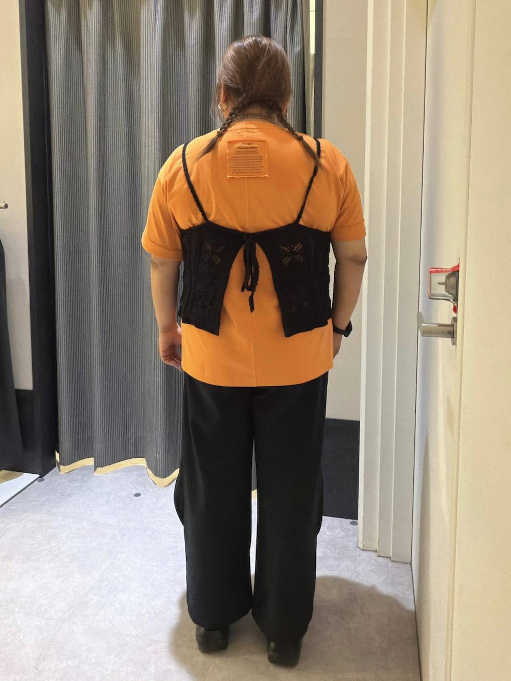 オレンジ系のTシャツ/カットソー、ブラック系のキャミソール、ブラック系のその他パンツを着用したレディースの春コーディネートの3枚目の写真