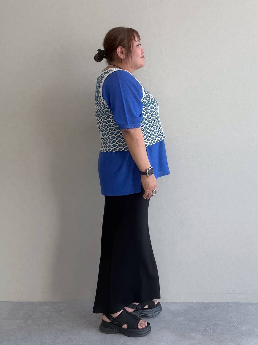 ブラック系のスカート、ブルー系のTシャツ/カットソー、ブラック系のサンダルを着用したレディースの春コーディネートの2枚目の写真