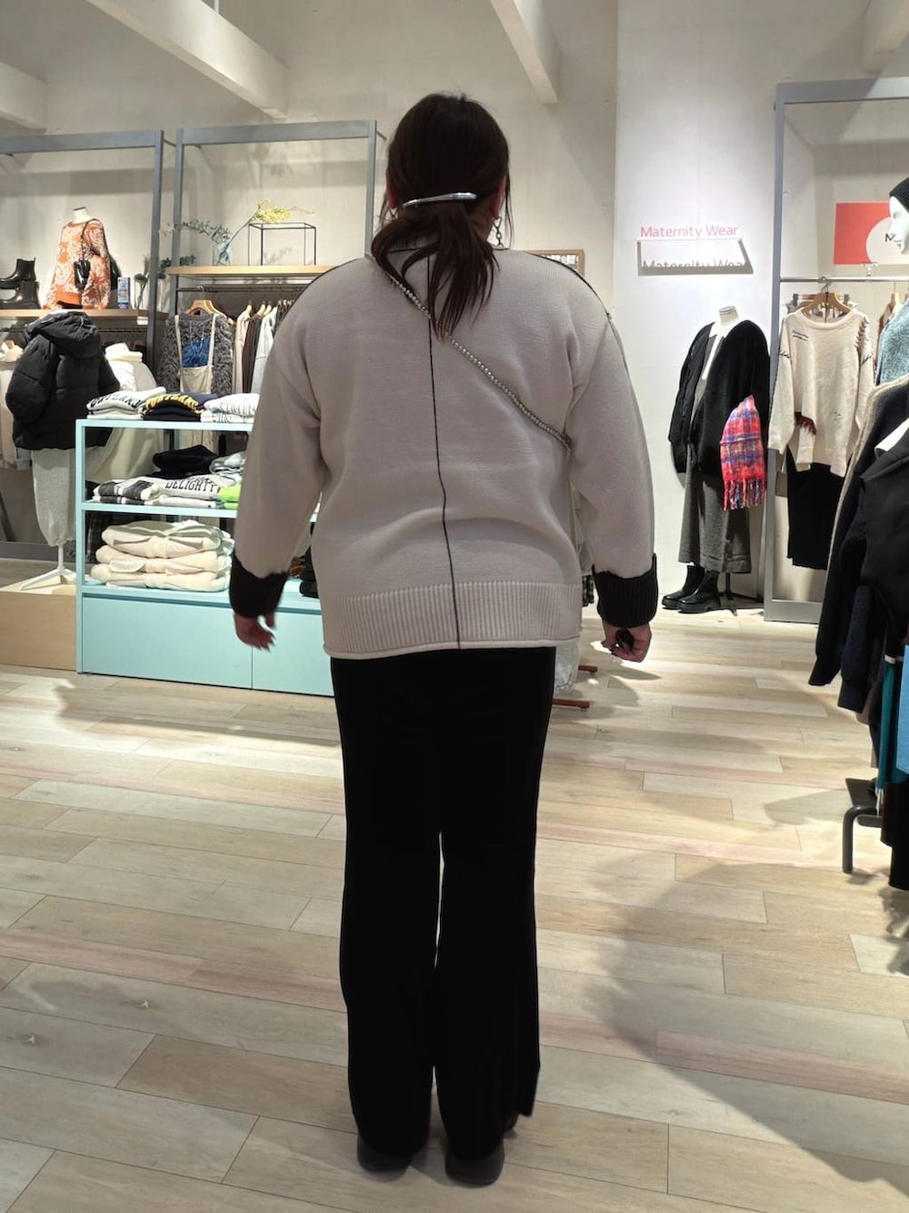 ブラック系のその他パンツ、ブラック系のブーツ、ホワイト系のニット/セーターを着用したレディースの冬コーディネートの3枚目の写真