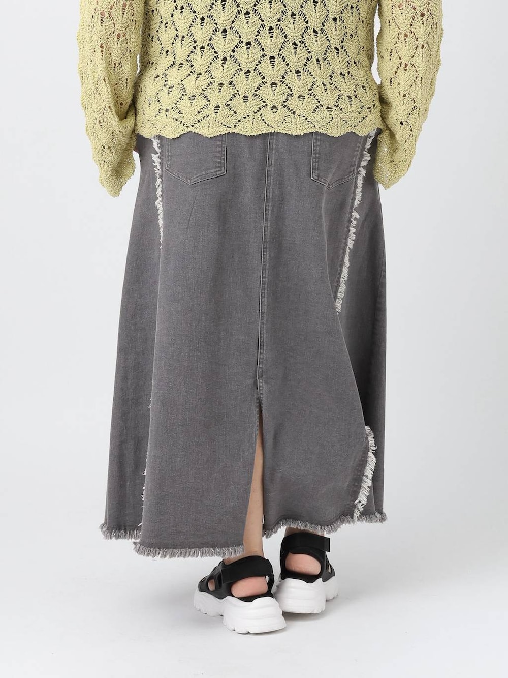 ブラック系のタンクトップ、ブラック系のサンダル、グリーン系のニット/セーターを着用したレディースの春コーディネートの4枚目の写真