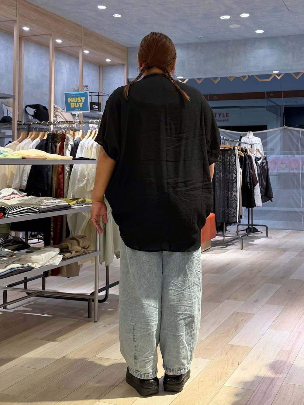 ブルー系のデニムパンツ、ブラック系のシャツ/ブラウス、シルバー系のネックレスを着用したレディースの春コーディネートの3枚目の写真