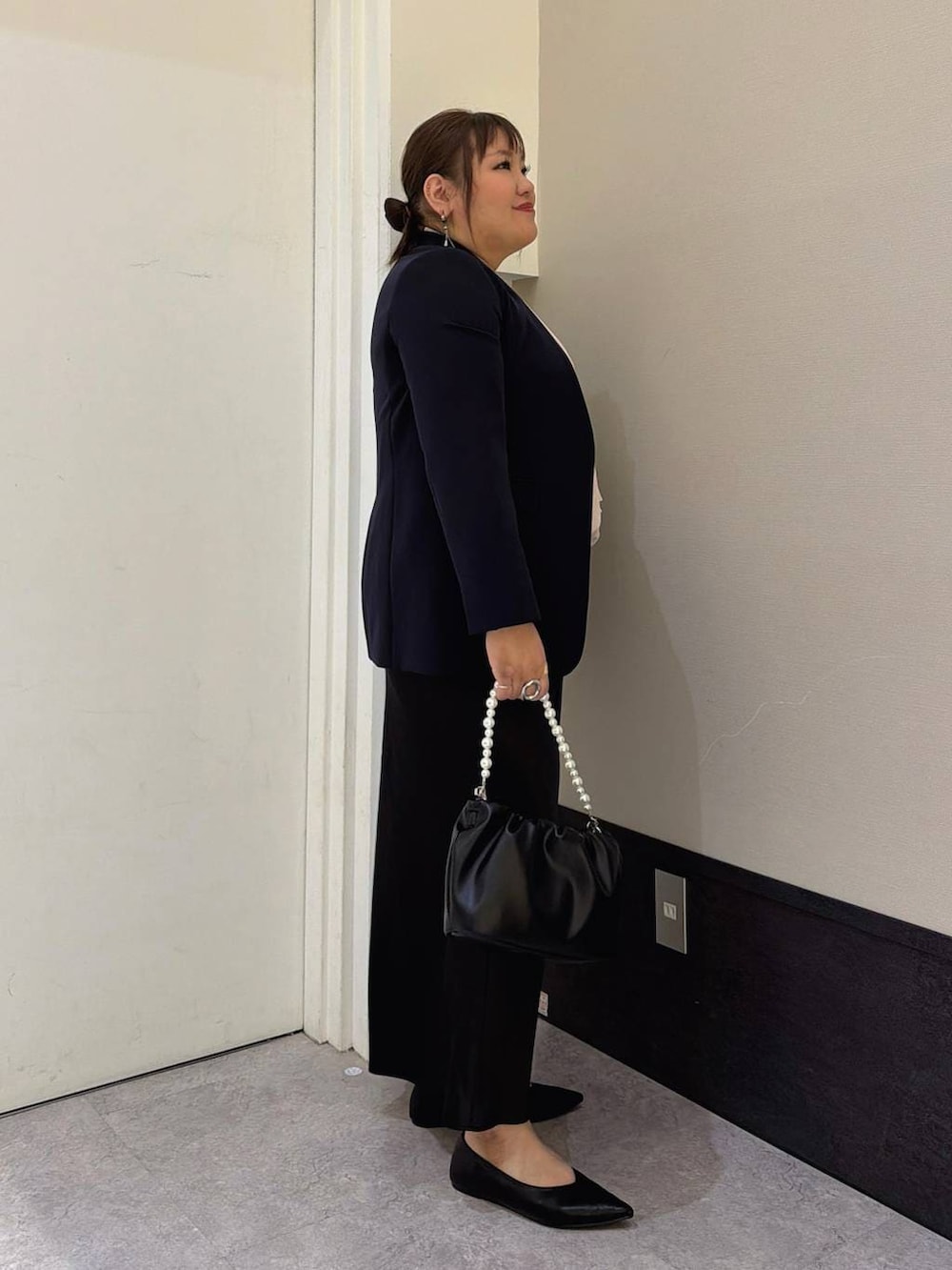 ブラック系のスカート、ブルー系のテーラードジャケット、ピンク系のシャツ/ブラウスを着用したレディースの冬コーディネートの2枚目の写真