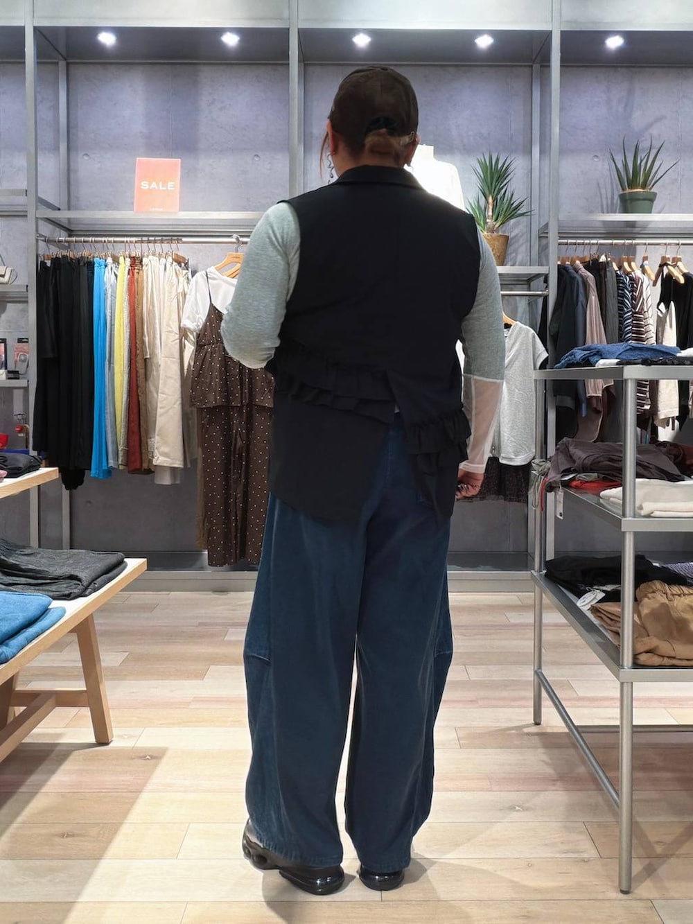ブルー系のデニムパンツ、ブラック系のベスト、グレー系のTシャツ/カットソーを着用したレディースの秋コーディネートの3枚目の写真