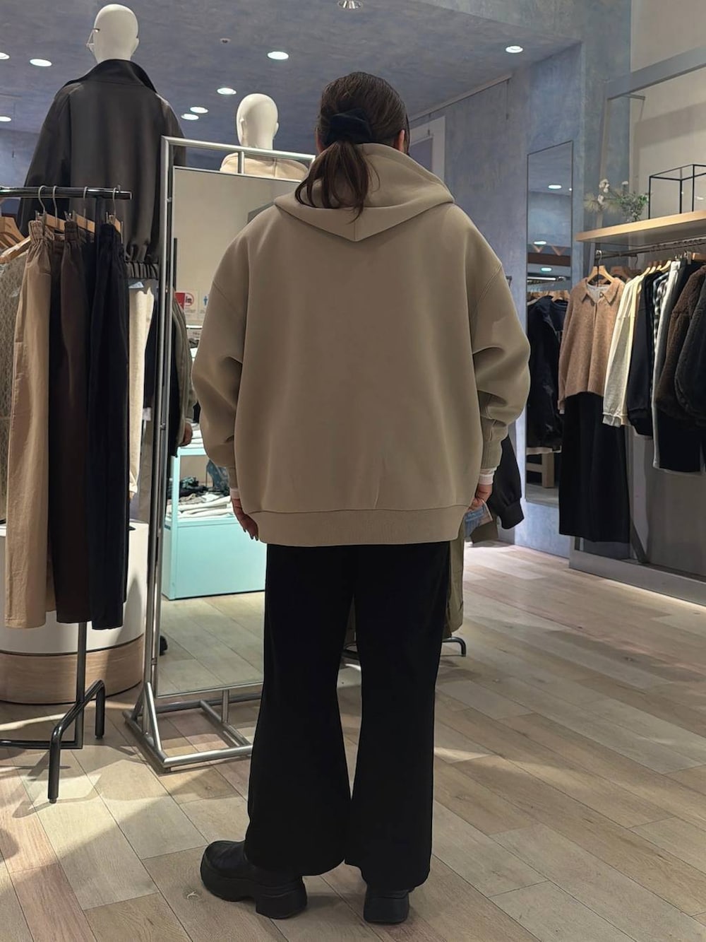 ホワイト系のTシャツ/カットソー、ベージュ系のパーカー、ブラック系のブーツを着用したレディースの冬コーディネートの3枚目の写真