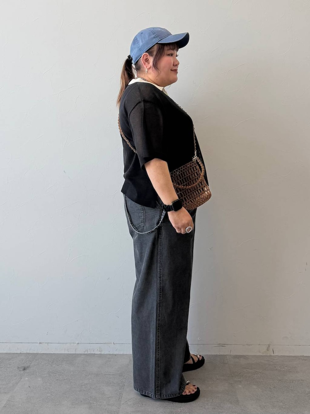 グレー系のサロペット/オーバーオール、ブラック系のサンダル、ブラック系のニット/セーターを着用したレディースの春コーディネートの2枚目の写真