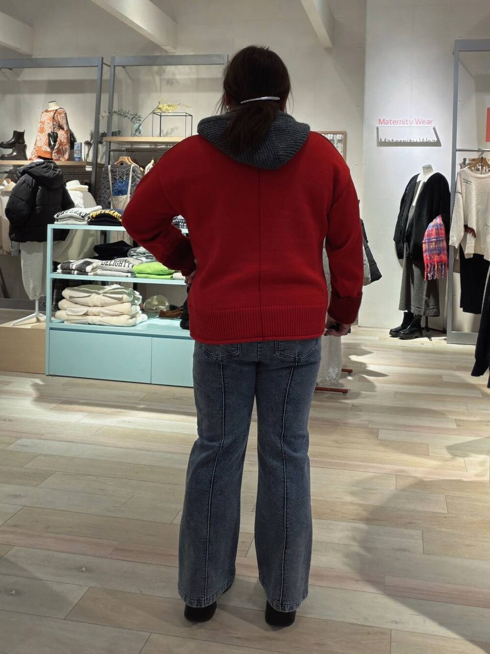 ブラック系のブーツ、レッド系のニット/セーター、ブルー系のマタニティウェア/グッズを着用したレディースの冬コーディネートの3枚目の写真
