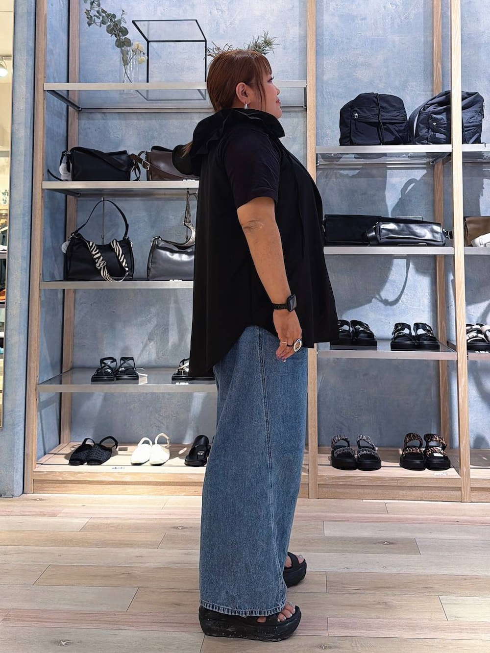 ブルー系のデニムパンツ、シルバー系のネックレスを着用したレディースの春コーディネートの2枚目の写真