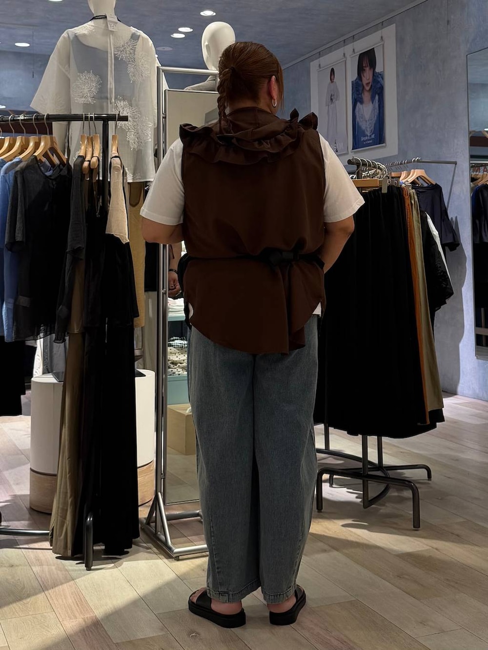ブラック系のサンダル、ブルー系のデニムパンツ、ブラック系のボディバッグ/ウエストポーチを着用したレディースの春コーディネートの3枚目の写真