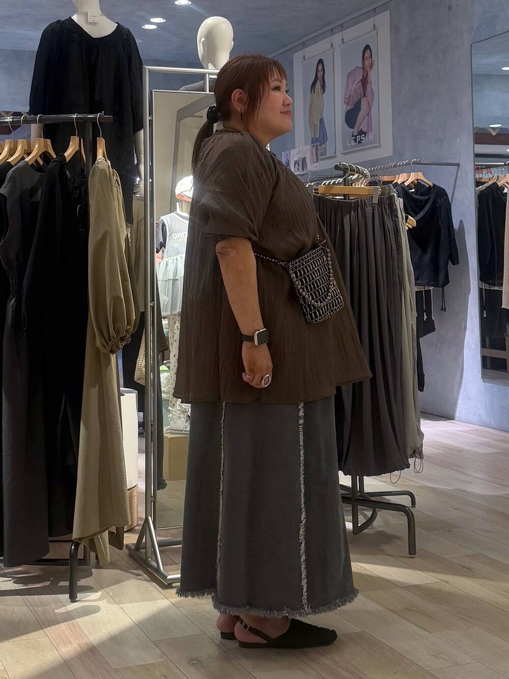 シルバー系のショルダーバッグ、ブラック系のパンプス、ブラウン系のシャツ/ブラウスを着用したレディースの春コーディネートの2枚目の写真