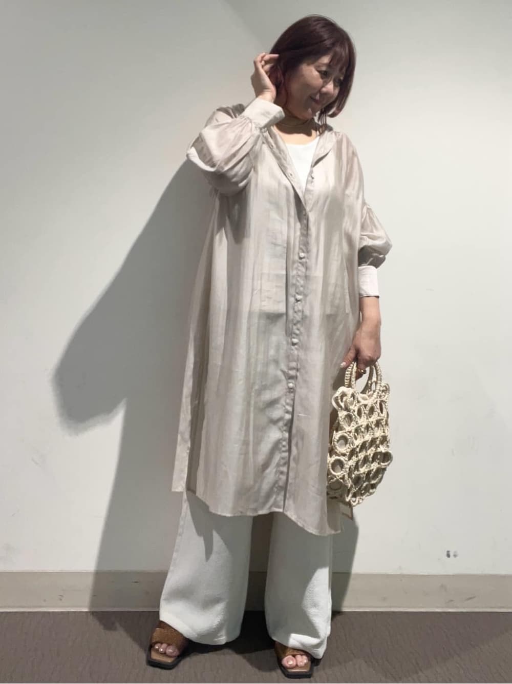 ベージュ系のワンピース、ホワイト系のその他パンツ、ホワイト系のハンドバッグを着用したレディースの春コーディネートの3枚目の写真