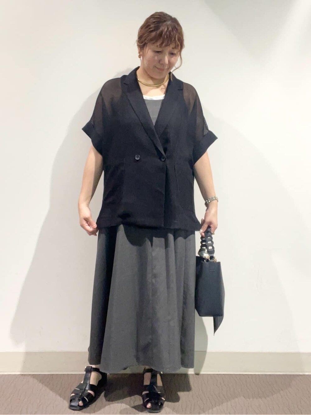 グレー系のワンピース、ブラック系のショルダーバッグ、ブラック系のサンダルを着用したレディースの夏コーディネートの6枚目の写真