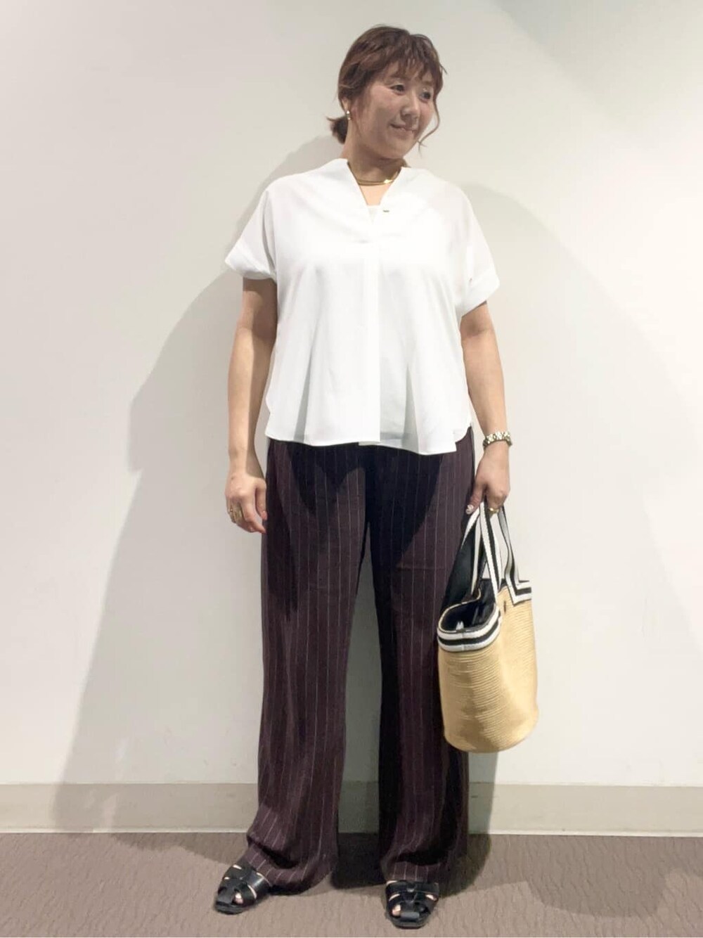 ホワイト系のシャツ/ブラウス、ブラウン系のその他パンツ、ベージュ系のトートバッグを着用したレディースの夏コーディネートの2枚目の写真