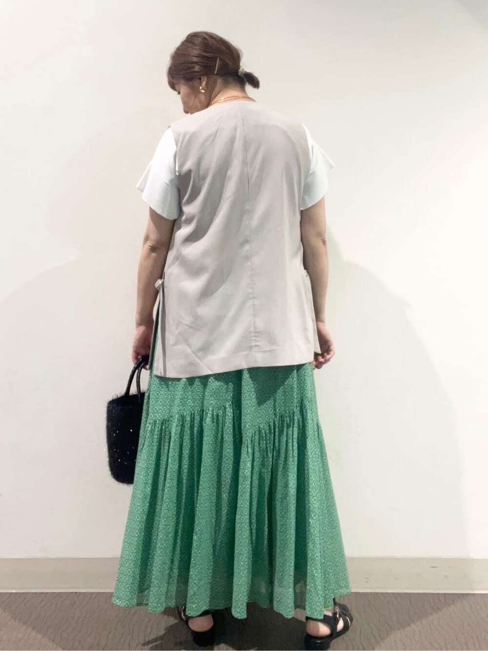 ホワイト系のニット/セーター、グレー系のベスト、ブラック系のトートバッグを着用したレディースの夏コーディネートの3枚目の写真