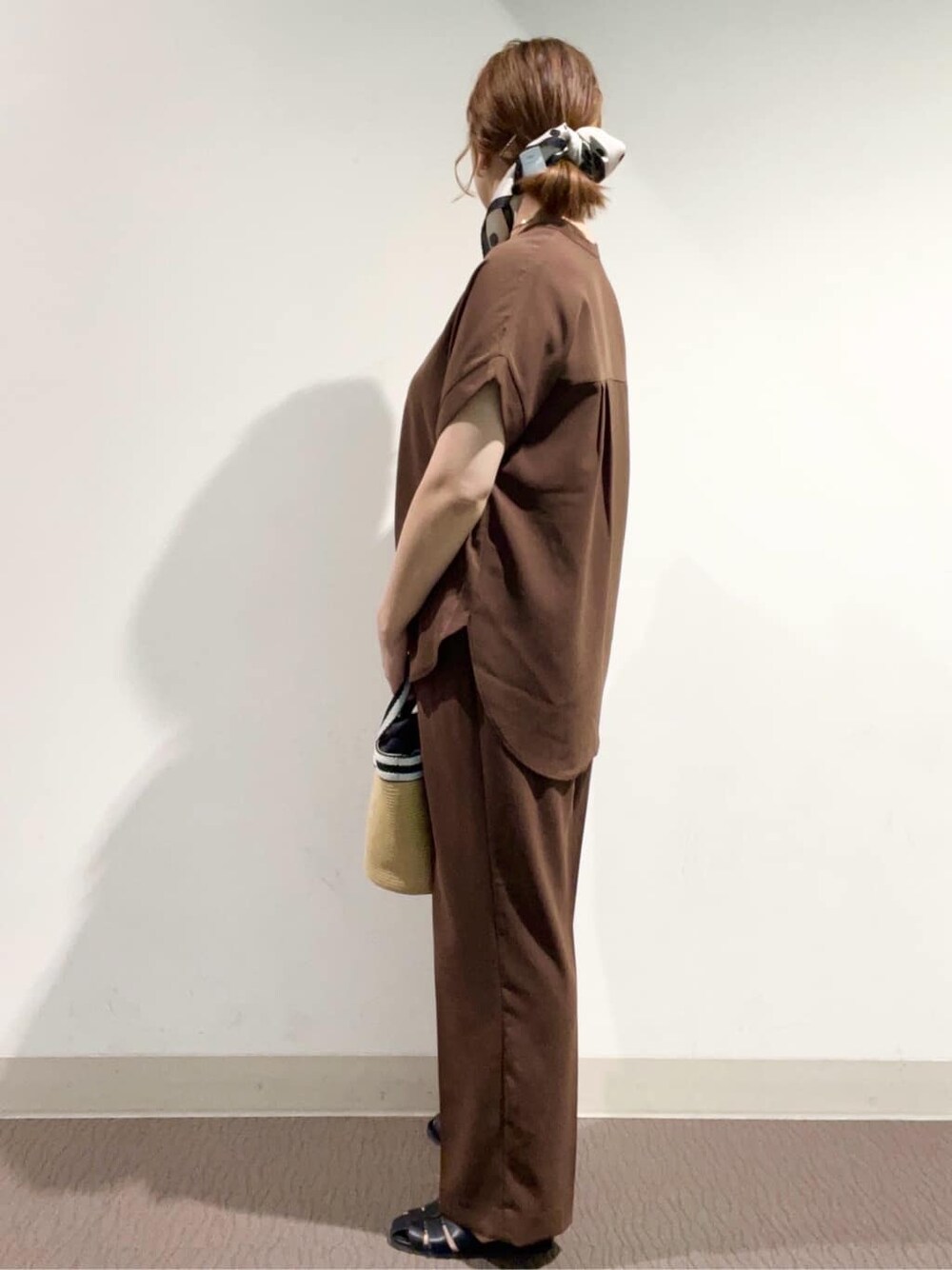 ブラウン系のシャツ/ブラウス、ブラウン系のその他パンツ、ベージュ系のトートバッグを着用したレディースの春コーディネートの3枚目の写真