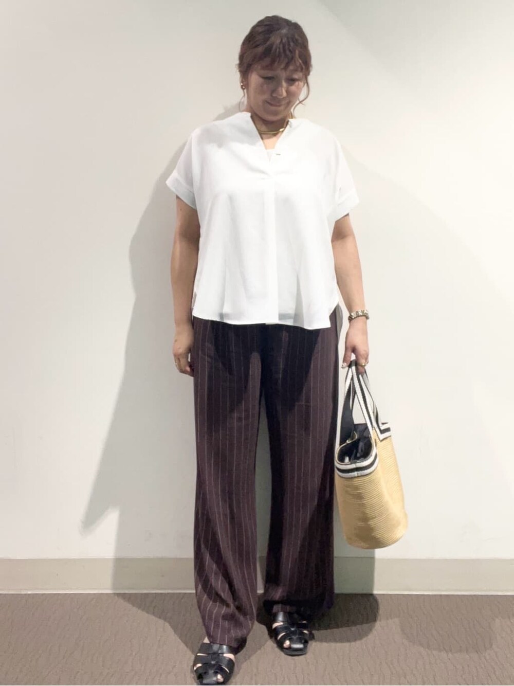 ホワイト系のシャツ/ブラウス、ブラウン系のその他パンツ、ベージュ系のトートバッグを着用したレディースの夏コーディネートの3枚目の写真