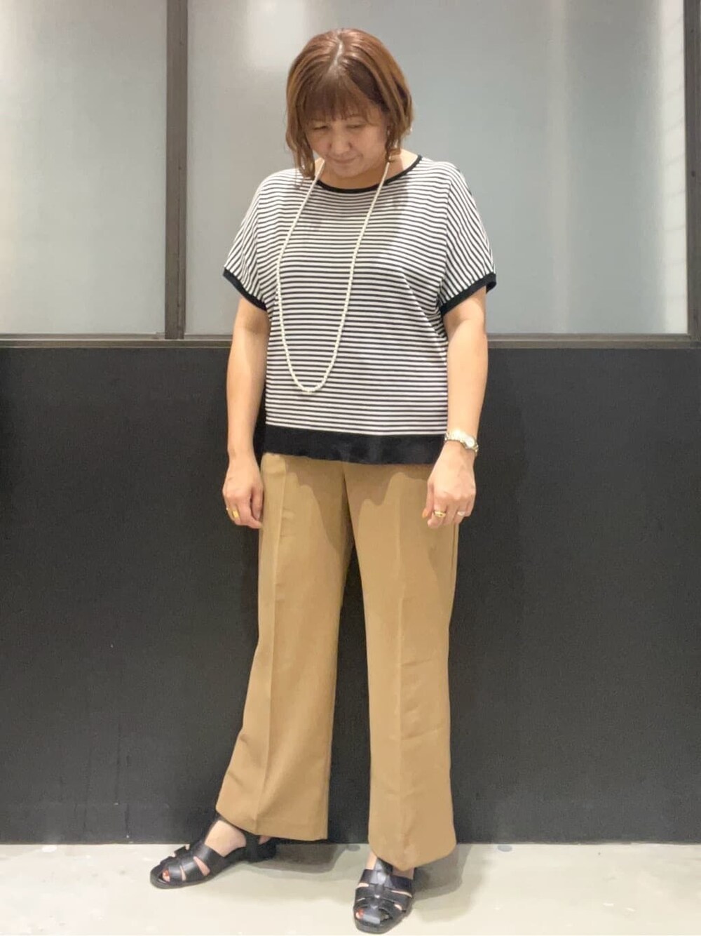 ブラック系のニット/セーター、イエロー系のその他パンツ、ブラック系のボストンバッグを着用したレディースの夏コーディネートの4枚目の写真