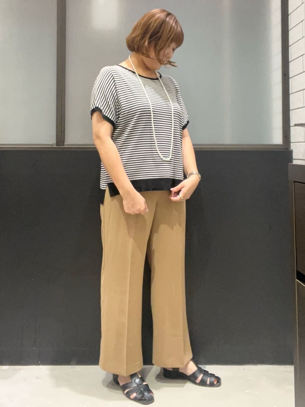 ブラック系のニット/セーター、イエロー系のその他パンツ、ブラック系のボストンバッグを着用したレディースの夏コーディネートの3枚目の写真