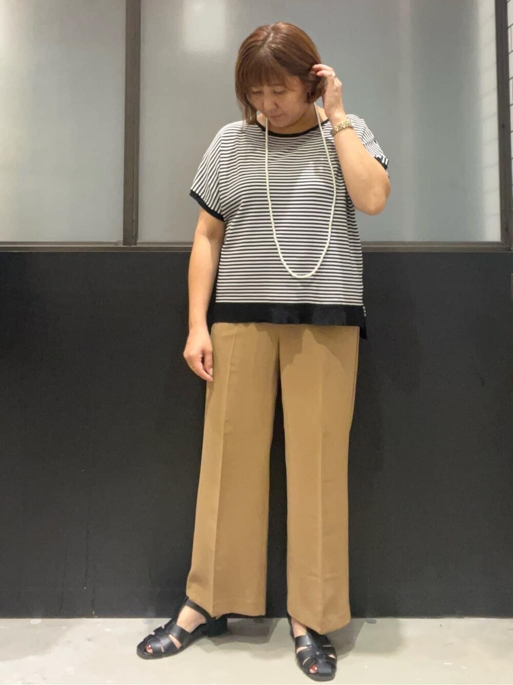 ブラック系のニット/セーター、イエロー系のその他パンツ、ブラック系のボストンバッグを着用したレディースの夏コーディネートの5枚目の写真