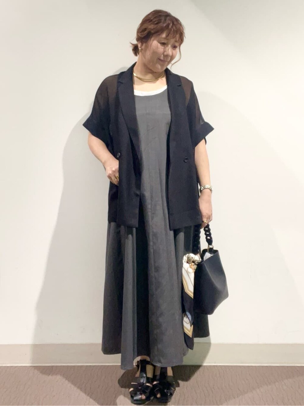 グレー系のワンピース、ブラック系のショルダーバッグ、ブラック系のサンダルを着用したレディースの夏コーディネートの2枚目の写真
