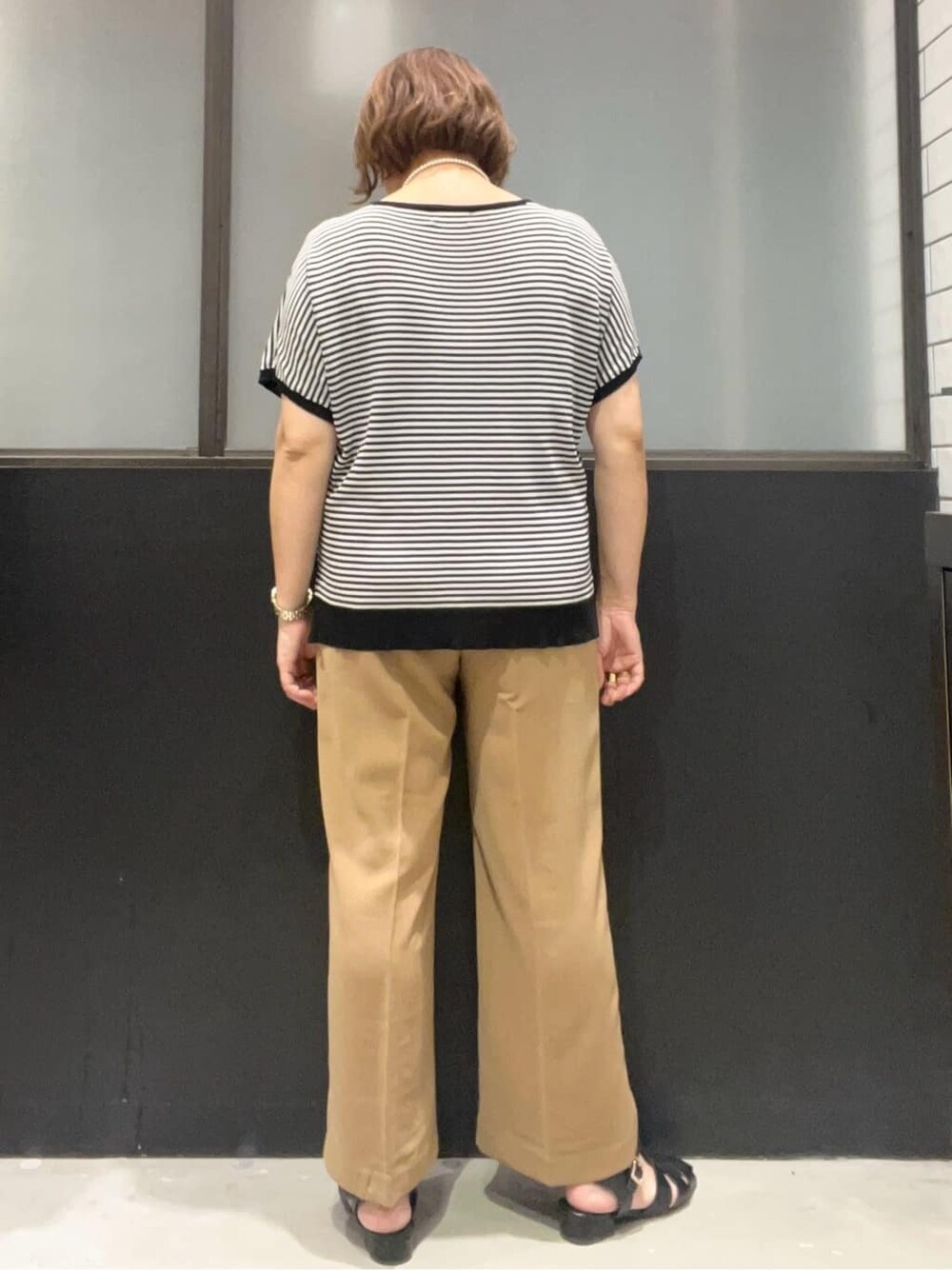 ブラック系のニット/セーター、イエロー系のその他パンツ、ブラック系のボストンバッグを着用したレディースの夏コーディネートの6枚目の写真