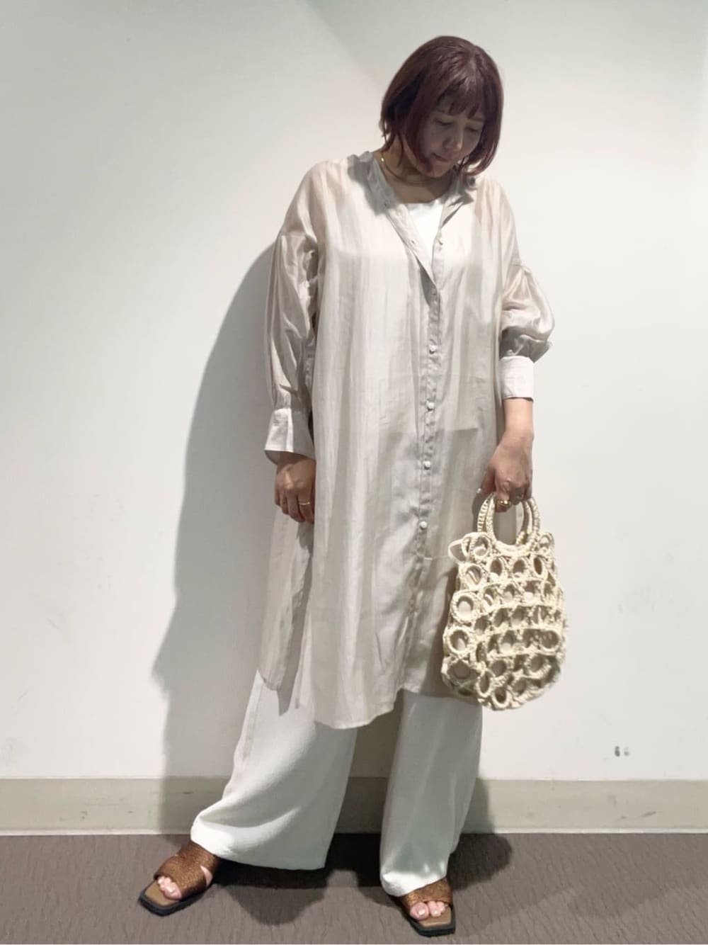 ベージュ系のワンピース、ホワイト系のその他パンツ、ホワイト系のハンドバッグを着用したレディースの春コーディネートの2枚目の写真