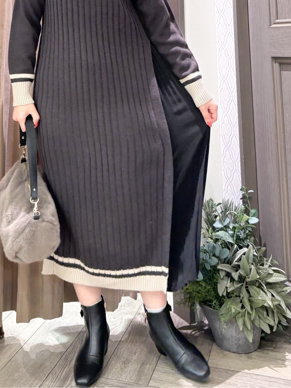 グレー系のワンピース、グレー系のショルダーバッグを着用したレディースの冬コーディネートの4枚目の写真