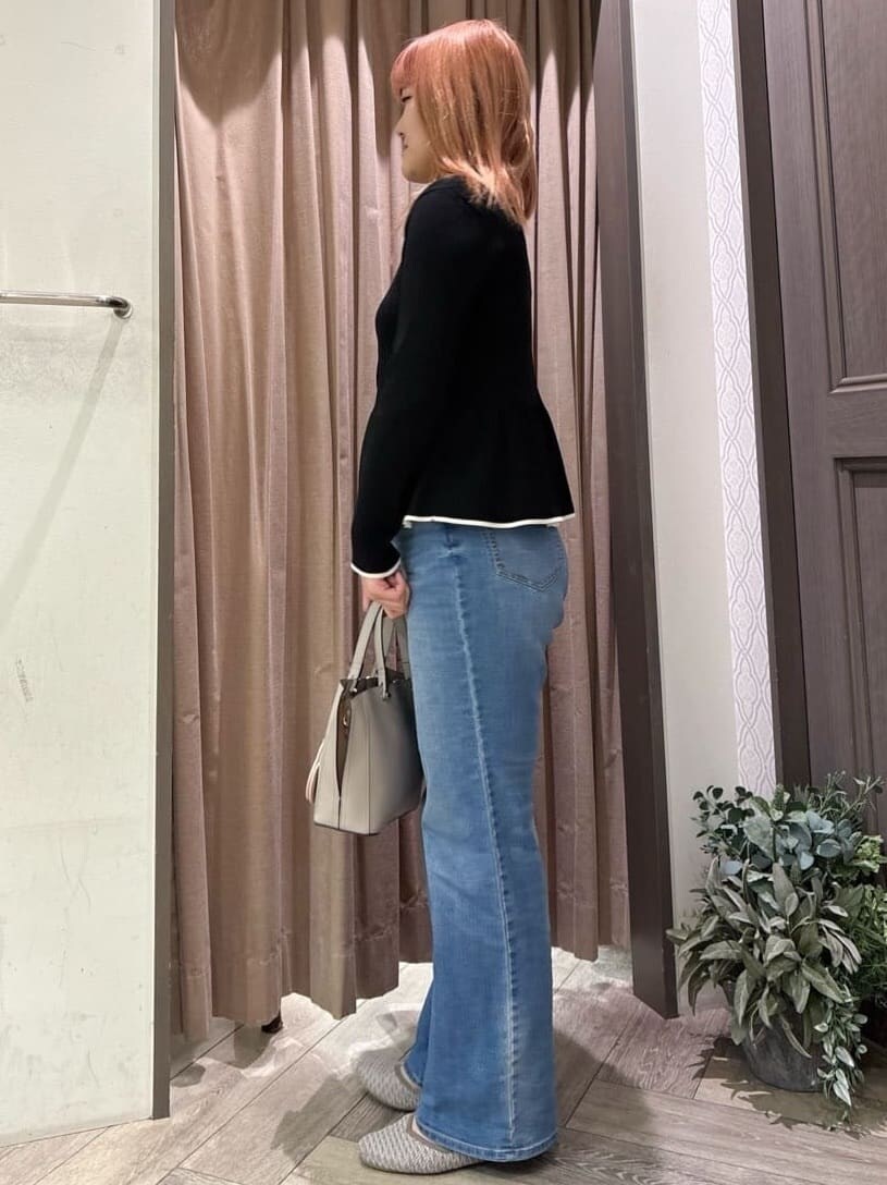 ブラック系のニット/セーター、ブルー系のデニムパンツ、グレー系のトートバッグを着用したレディースの春コーディネートの2枚目の写真