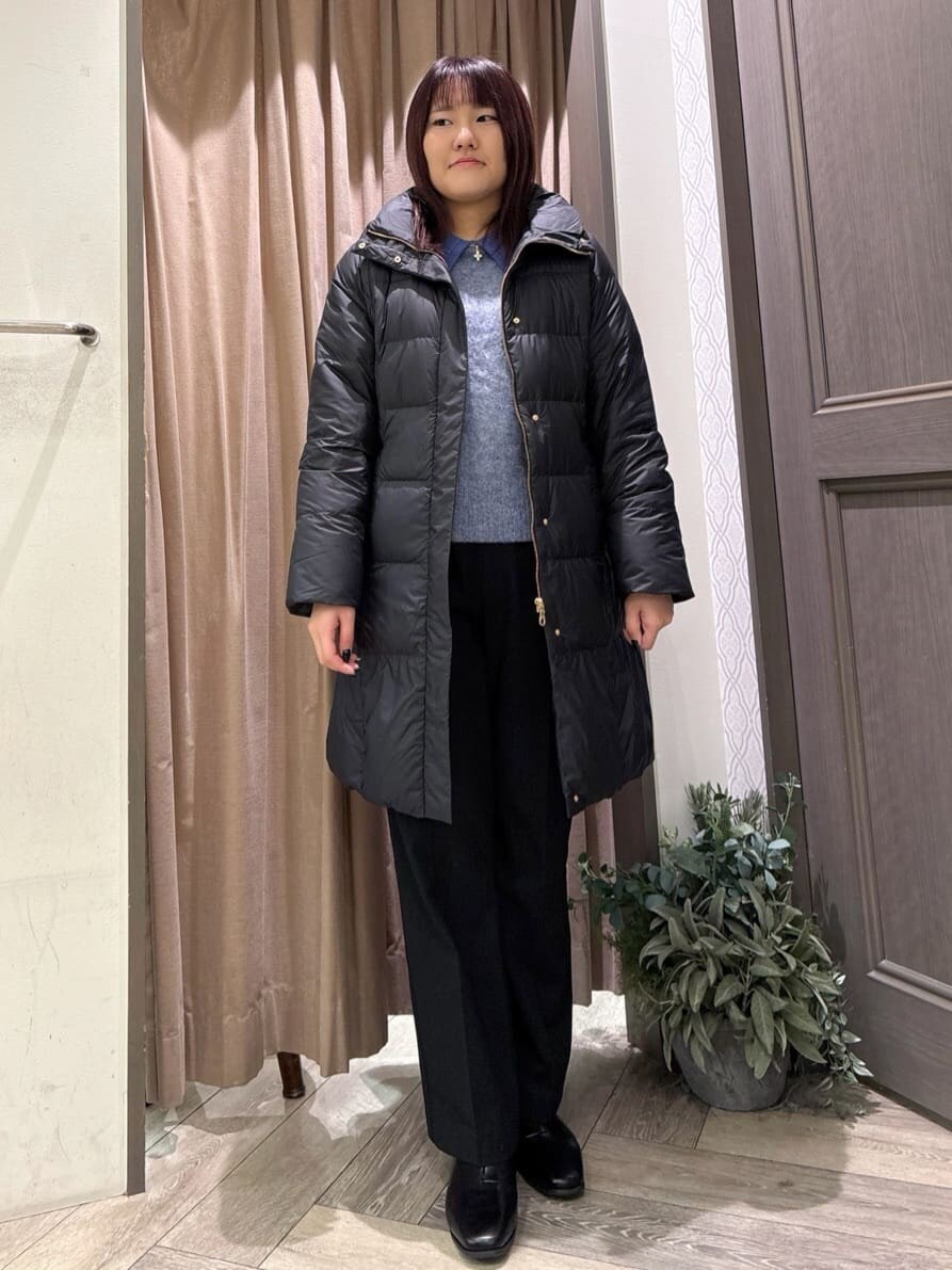 ブラック系のダウンジャケット/コート、ブルー系のニット/セーター、ブラック系のその他パンツを着用したレディースの秋コーディネートの7枚目の写真