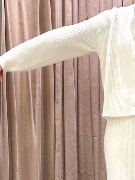 グレー系のニット/セーター、ホワイト系のカーディガン/ボレロ、ホワイト系のスカートを着用したレディースの秋コーディネートの4枚目の写真