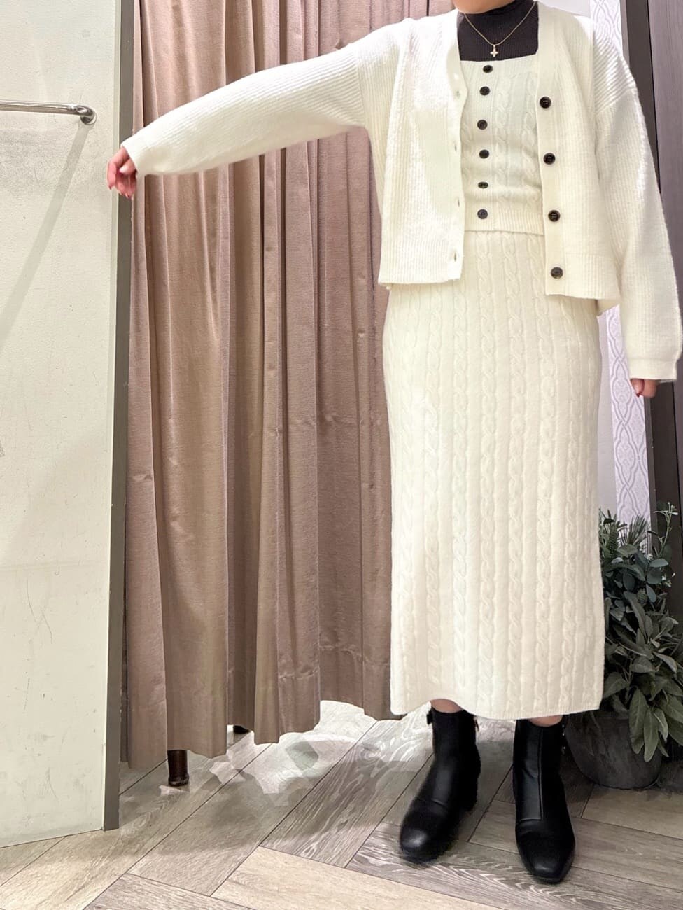 ホワイト系のカーディガン/ボレロ、ホワイト系のニット/セーター、グレー系のニット/セーターを着用したレディースの秋コーディネートの4枚目の写真