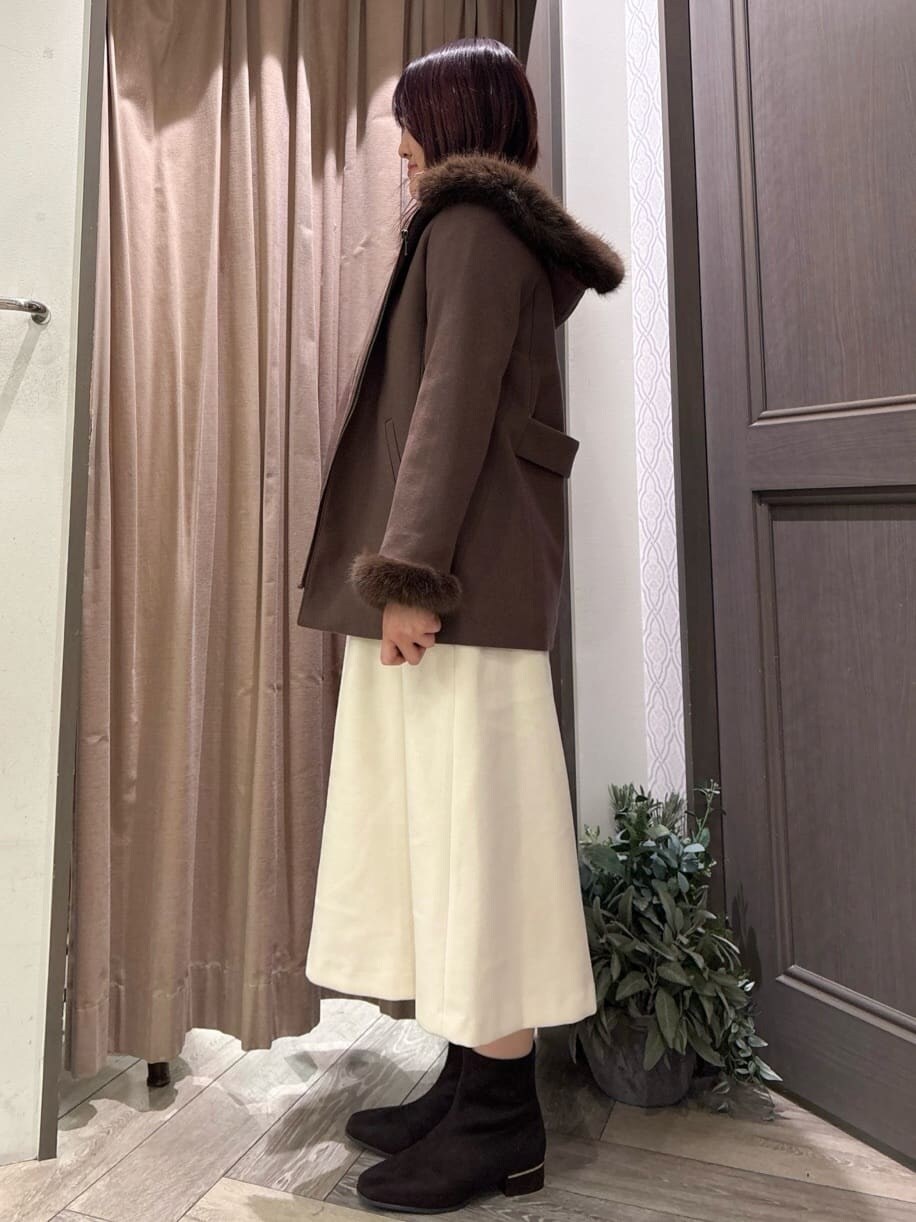 ブラウン系のその他アウター、ホワイト系のニット/セーター、ホワイト系のスカートを着用したレディースの冬コーディネートの2枚目の写真